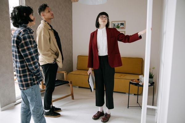 Realtor guiding potential buyers through a stylish apartment viewing.