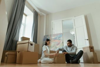 A young couple unpacks boxes in their new apartment, starting their domestic journey.